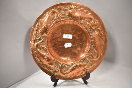 An Arts and crafts charger having embossed fish border. In a Newyln school style