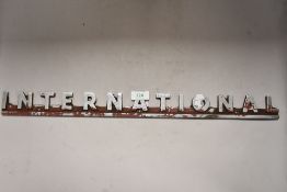 Cast metal haulage or wagon badge reading International
