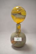 An art glass bottle having large statement stopper.