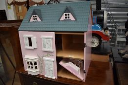 A mid to late 20th century childrens toy doll house with accessories furniture and dolls