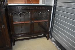 A 20th century dark oak book case having leaded light doors
