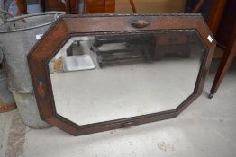 An antique carved oak framed bevelled glass wall mirror.