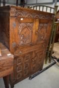 A 20th century cocktail drinks cabinet having oak frame with carved doors