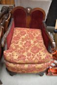 A late 19th or early 20th Century low seat east chair having scroll arms and ball and claw feet
