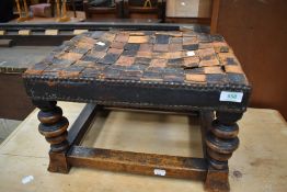 A Victorian foot stool having turned legs with cross band lattice leather top