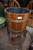 A coopered oak bucket on footed base