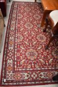 A traditional carpet square in orange and red shades