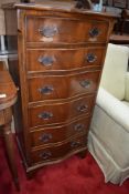 A 20th century tall chest of six drawers having serpantine front