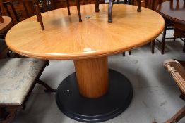 A modern circular dining table on cotton reel style base