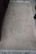 A Chinese style fireside rug, cream with neutral pattern, approx. 153 x 77cm