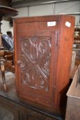 A 19th Century stained frame corner cupboard of small proportions having carved door