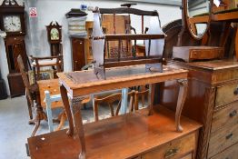 A stained frame coffee table having carved vine decoration and a mahogany effect magazine rack