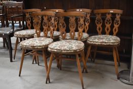 A set of six Ercol dining chairs, fleur de lys style backs, mid/dark colour