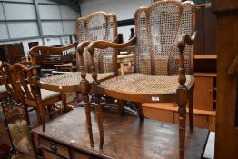 A pair of early to mid 20th Century salon armchairs having bergere canework seats and backs