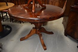 A Ducal red stain pine extending dining table on triple splay legs