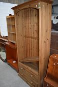 A natural pine narrow bookshelf having double drawer base