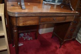 A Victorian flip top table in mahogany having drawer and fluted legs