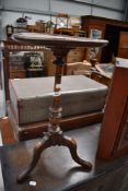 A late 19th or early 20th Century oak wine table having turned column and triple splay legs,
