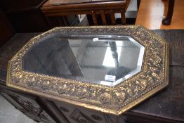 A vintage brass canted wall mirror