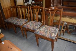 A set of four vintage pine dining chairs having shaped rail backs and turned legs