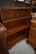 A stained pine book shelf having two shelves, AF, surface scratching.