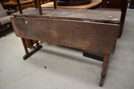 A period drop leaf kitchen or side table having turned legs and base rail