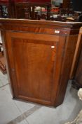 A 19th Century oak corner cupboard having mahogany cross banding