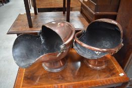 Two traditional copper coal helmets