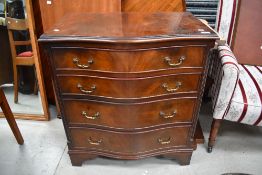 A reproduction serpentine chest of four drawers