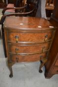 An early 20th Century period style low bedside or similar chest of three drawers on cabriole legs