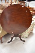 A 19th Century mahogany snap top pedestal table having circular top, turned column and triple