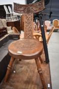 An Arts and Crafts oak spinning chair having extensive carved decoration