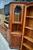 A stained pine corner cabinet having glass door to top.