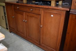 A stained oak side board having two centre drawers over cupboard, flanked by two further cupboards.