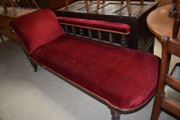 A Victorian mahogany framed chaise longue with turned rail back and red dralon upholstery