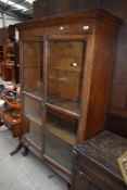 A late 19th/early 20th Century oak bookcase on shaped legs