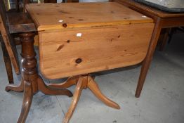 A modern pine pedestal table having drop leaves, turned column and quadruple splay legs , width