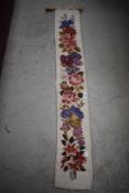 A vintage velvet backed needle point table runner having floral decoration.