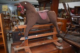 A vintage rocking horse, plush style on wood frame