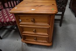A modern pine three drawer bedside chest