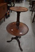 A two tier mahogany table having carved central column sat on the feet.