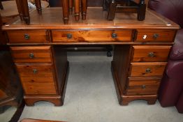 A pine key hole desk having leather to top, and eight drawers.