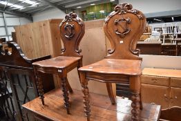 A pair of 19th Century oak hall chairs having crest backs