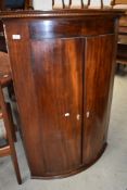A 19th Century mahogany corner cupboard having bow front