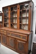 A Victorian mahogany bookcase having triple display section the base having one large and two