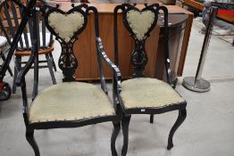 Two unusual late Victorian/Edwardian carved back chairs, heart shaped back rest and having black