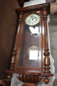 An early 20th century mahogany Vienna wall clock having ceramic dial with Roman numerals, with red