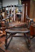 A traditional stained frame rocking chair, over stained and in some disrepair