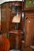 A reproduction Regency bow front corner display with cupboard to base