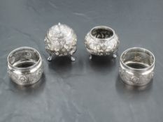 A pair of Eastern white metal condiments, with moulded foliate scroll decoration and three